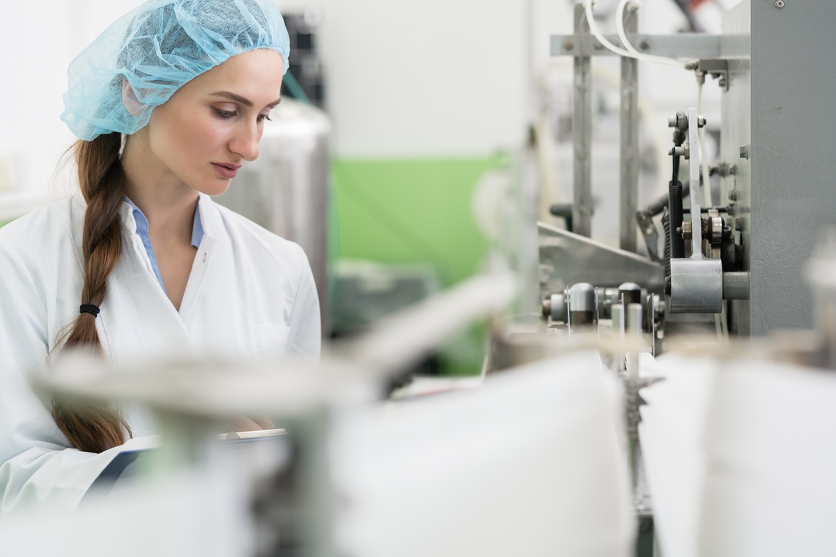 Happy,Female,Employee,Wearing,Protective,Headwear,And,White,Lab,Coat
